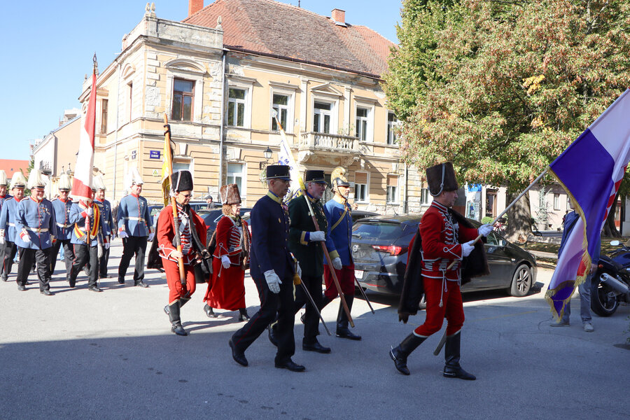 Uniformierte Gruppen marschieren mit Fahnen durch Varaždin