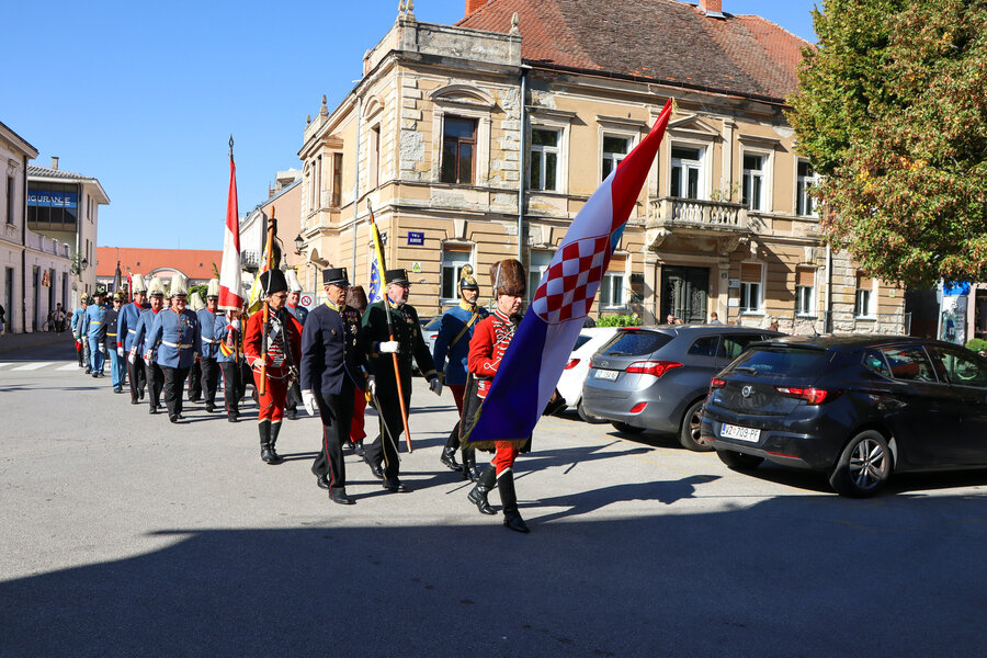 Uniformierte Gruppen marschieren mit Fahnen durch Varaždin
